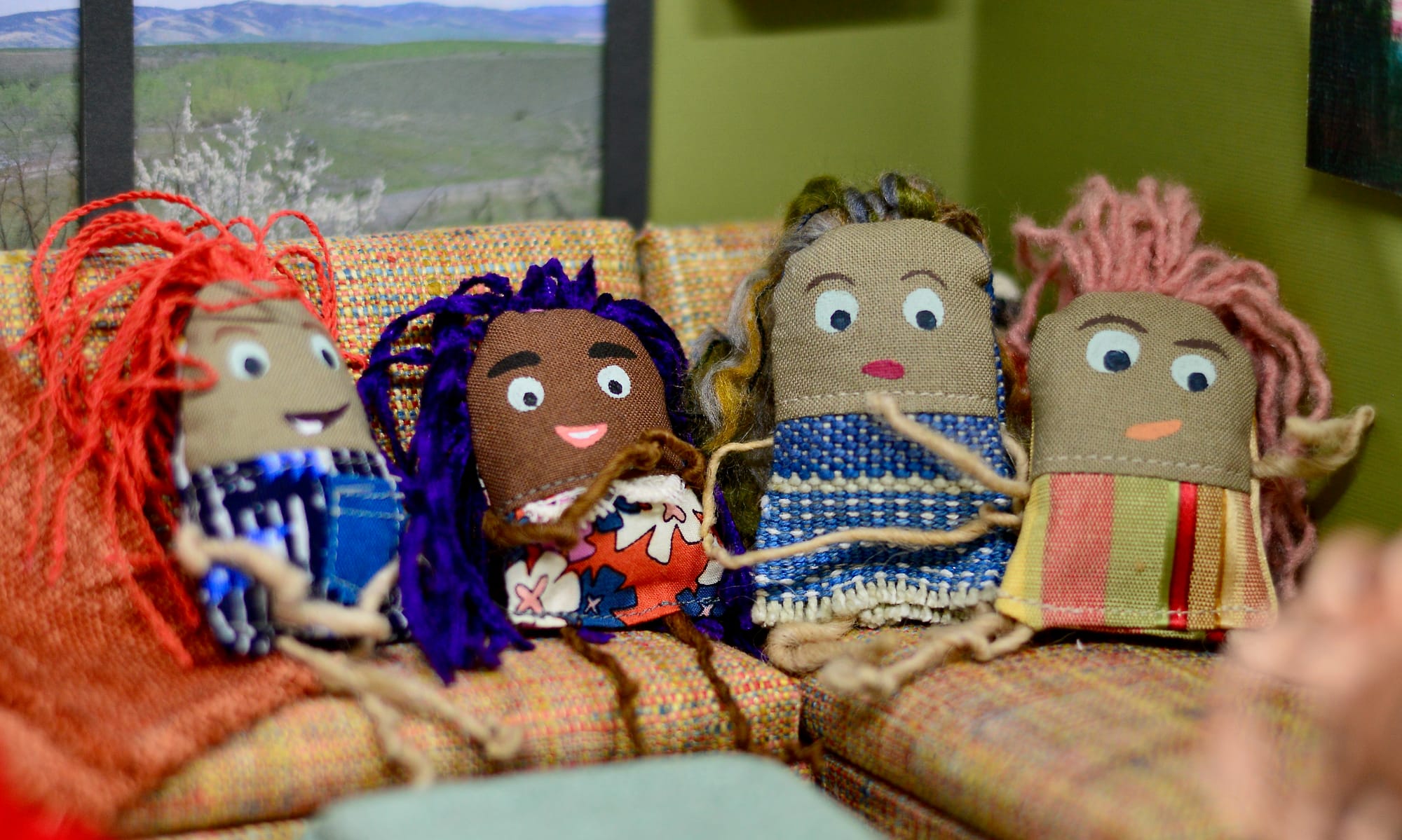 Tiny scrap-fabric dolls on a tiny doll couch.
