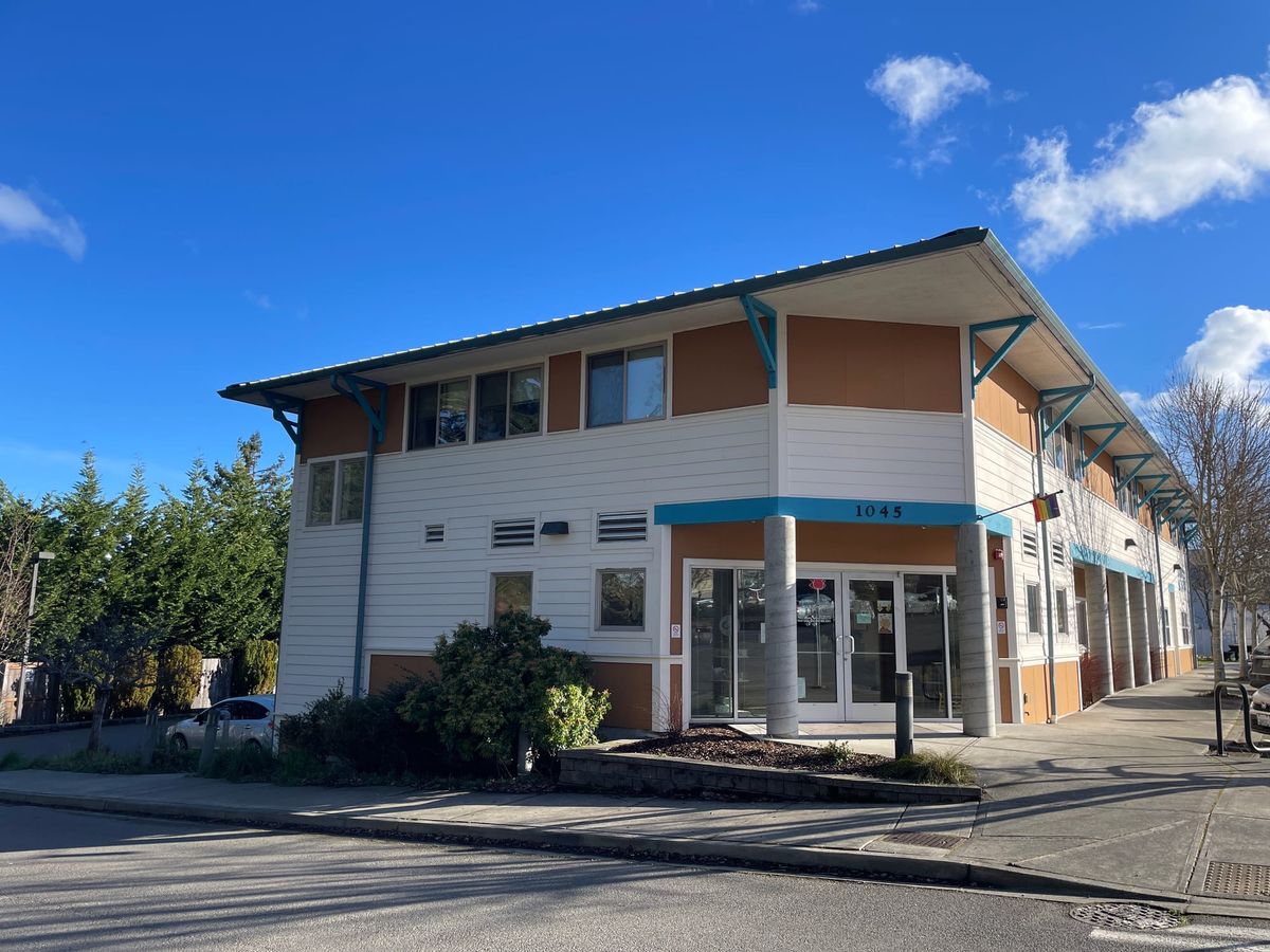Front corner entrance of the orange blue and white building that houses Dove House 
