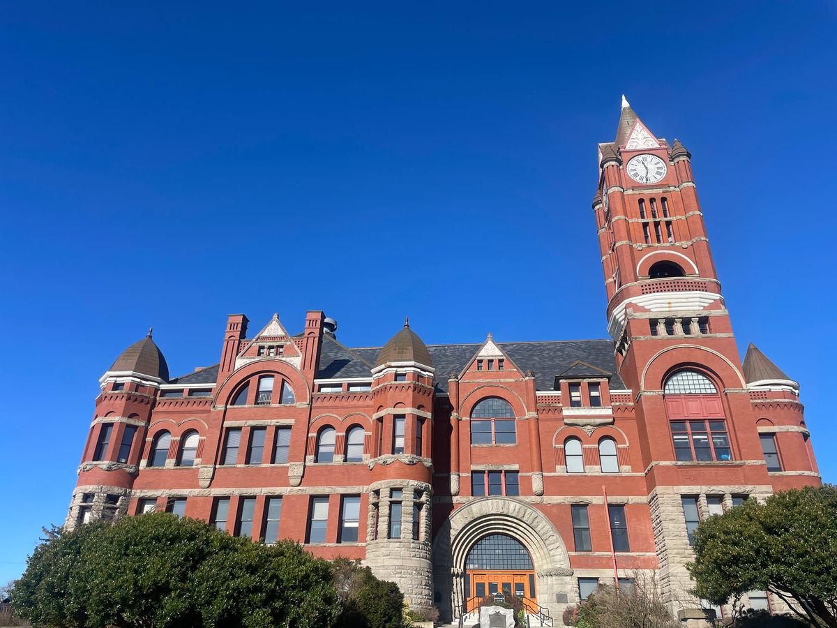 Front of the Jefferson County Courthouse, a large red brick building with a clock tower on the right side. 