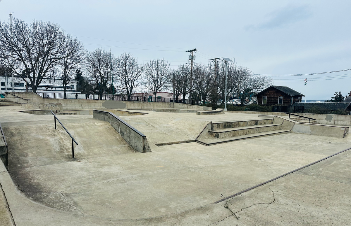 A picture of the Seamus Sims Skatepark, smooth gray concrete and rails for skateboarding