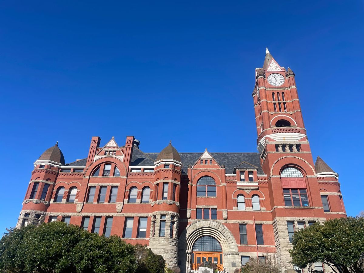 Front of the Jefferson County Courthouse, A large red brick building with a stone entrance and a clock tower on the right side.