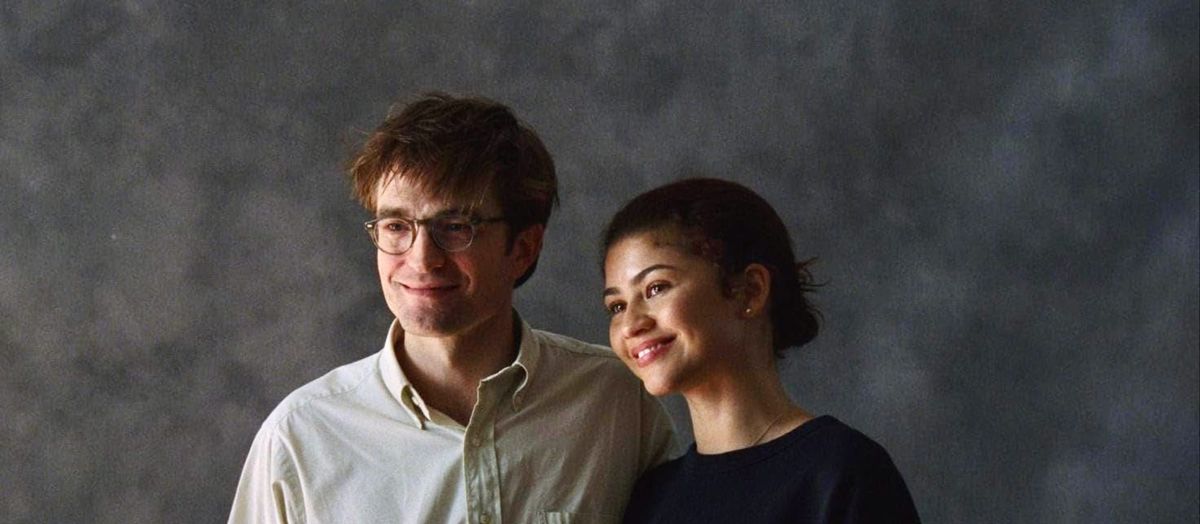 Robert Pattinson and Zendaya in a portrait photo with a gray background