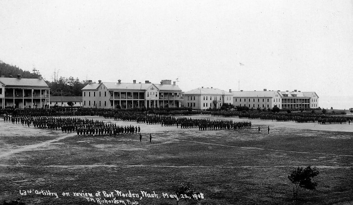 A black and white photo of soldiers in formation in front of barracks Building 202 (left), Building 201, Building 200 and Building 225.