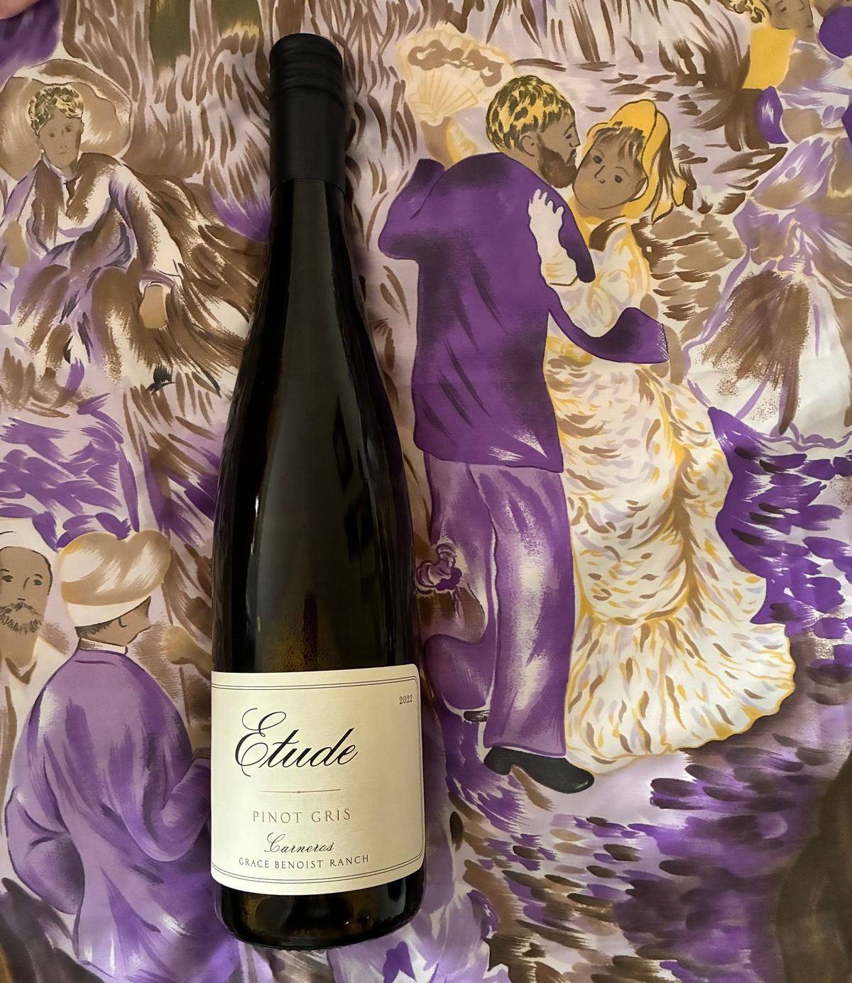 A bottle of Etude pinot gris from Carneros, Grace Benoist Ranch, in front of a painting of people dancing. 