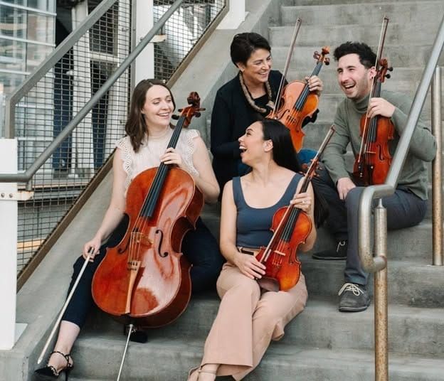  The Carpe Diem String Quartet sitting on a staircase. From left, Ariana Nelson, Korine Fujiwara, Marisa Ishikawa and Sam Weiser 