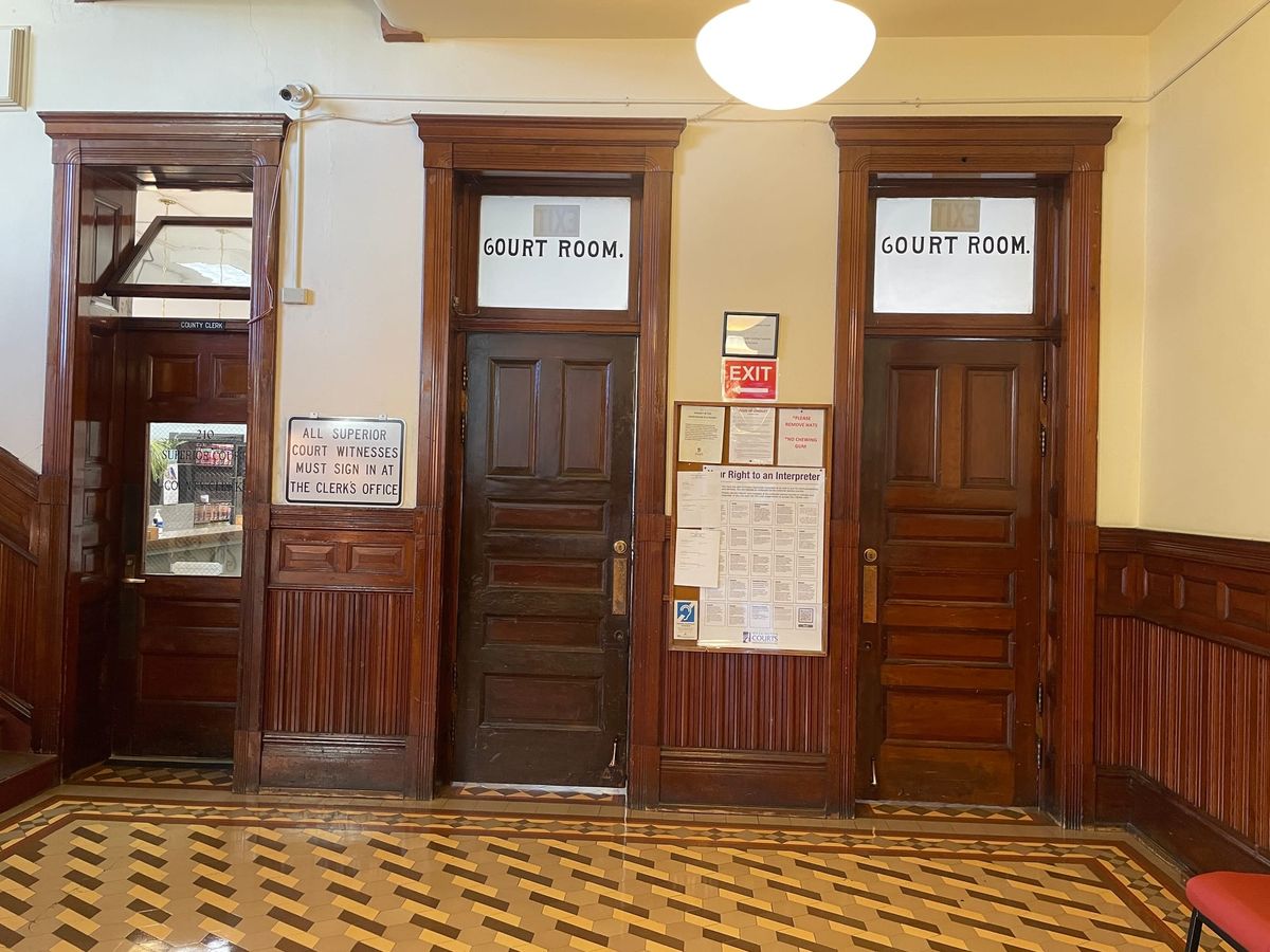 Jefferson County Superior courtroom doors. Three dark wooden doors with transom windows on tan and brown tile. 