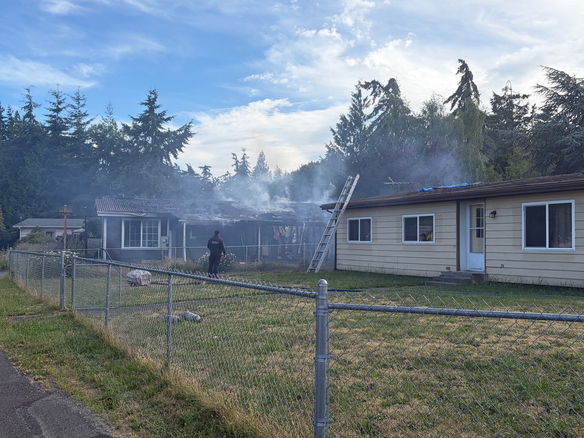 East Jefferson Fire Rescue actively controlling the residential structure fire in Towne Point. Seen is a smoldering single story house behind a fence.