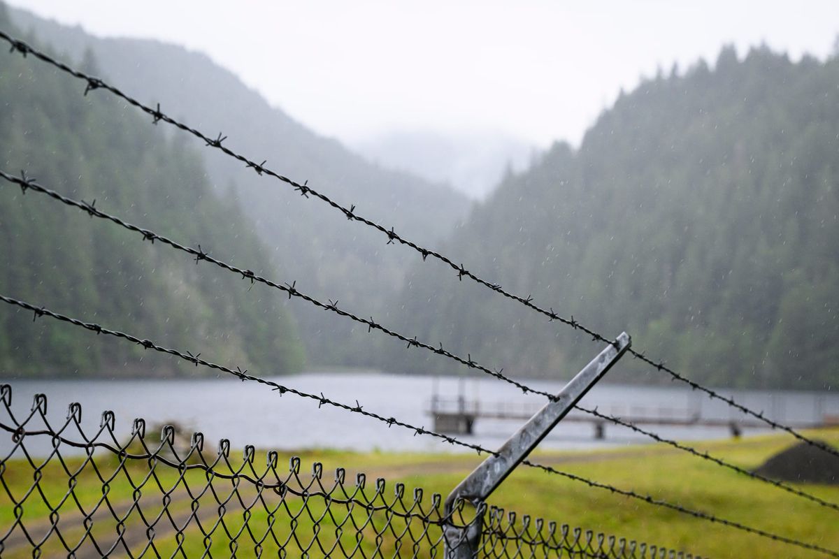 The city of Port Townsend's main water supply, Lords Lake, through chain link and barbed wire.