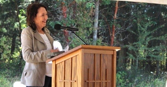 Senator Maria Cantwell standing at a lectern speaking at the Habitat for Humanity groundbreaking ceremony in Port Hadlock. 