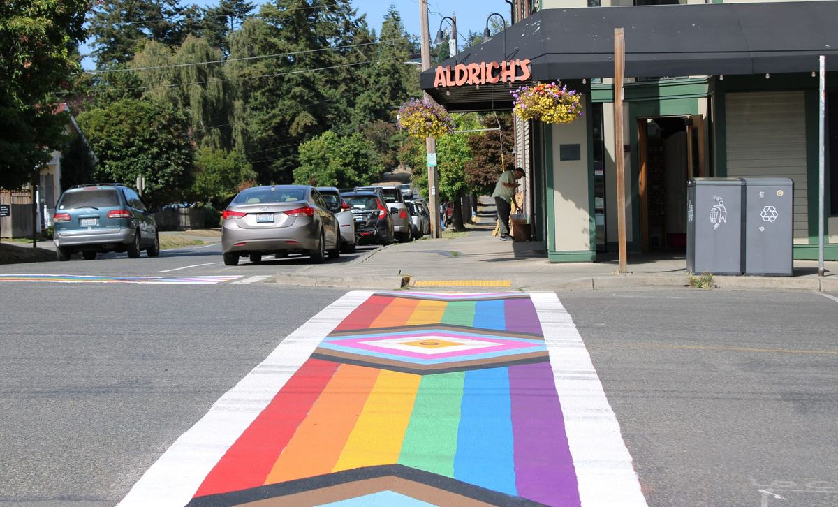 Completed Pride crosswalk made of rainbow stripes with BIPOC and Trans inclusive chevrons in front of Aldrich’s in Uptown.