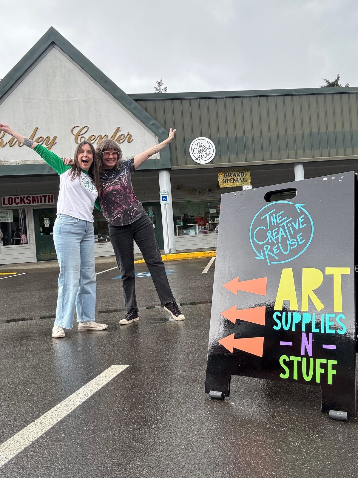Aran Galligan, left, and longtime friend Stephanie Moran standing next to The Creative ReUse sandwich board to the right with the Kivley Center behind them. 