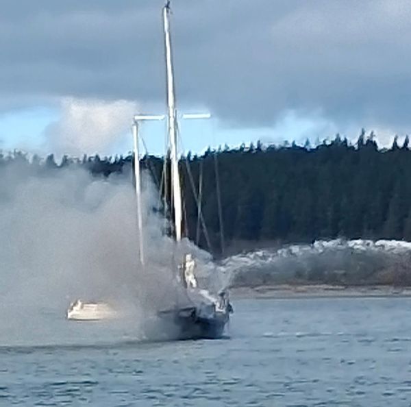 A photo of the Silver Shoals, a sailboat, on fire floating in Port Townsend bay