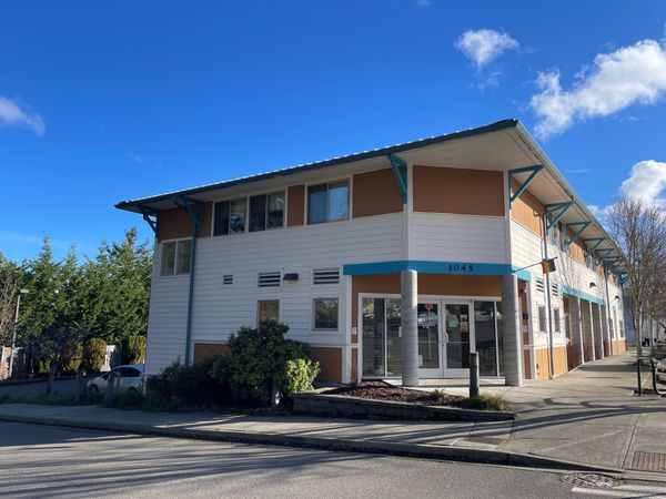 Front corner entrance of the orange blue and white building that houses Dove House 
