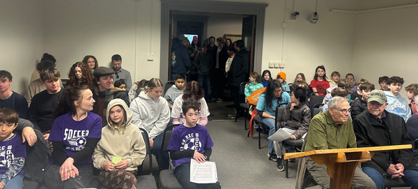 Youth and adult community members filling the County Commissioners Chambers and spilling into the hallway