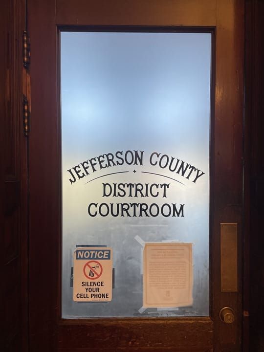 Courtroom door. A brown door with frosted glass in middle