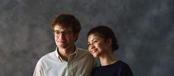 Robert Pattinson and Zendaya in a portrait photo with a gray background