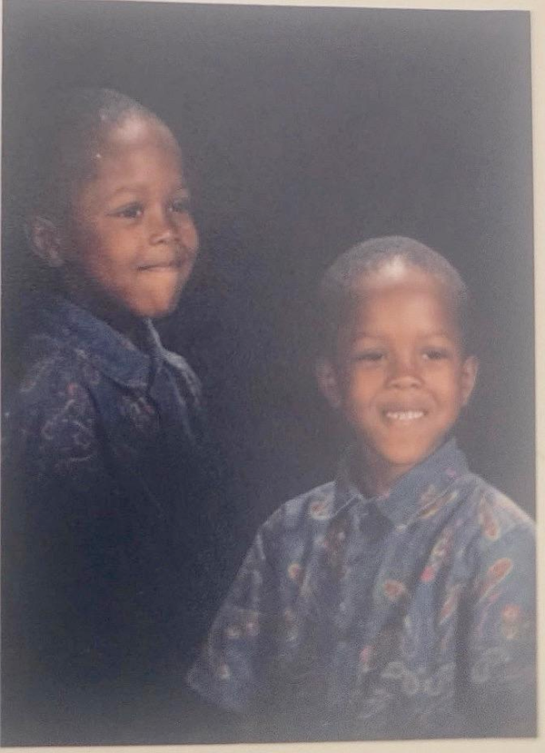 A smiling child in their school photo with a patterned short sleeve shirt on.