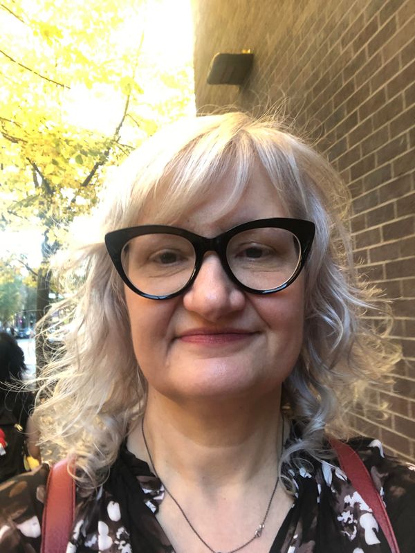  Attorney Jodi Backlund in black framed glasses and a black patterned shirt. 