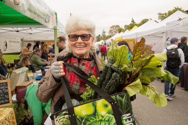 Rose Harris with her vegetable haul, with leafy greens coming out of her shopping bag. 