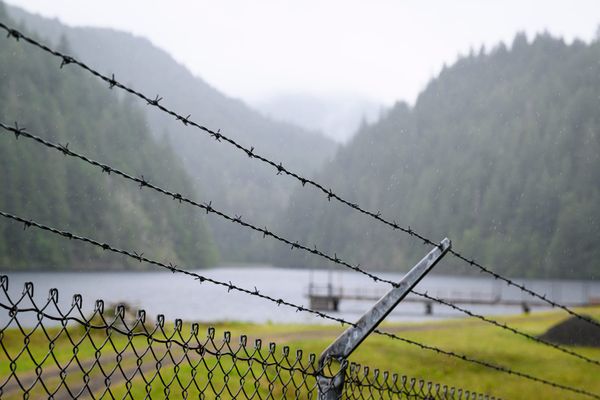 The city of Port Townsend's main water supply, Lords Lake, through chain link and barbed wire.