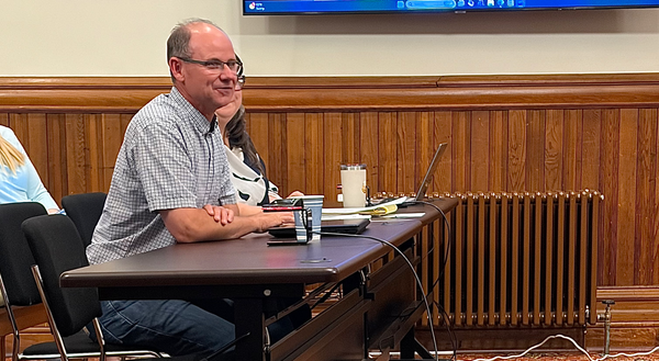 Public Works Director Steve King, at left, at a desk in the city council chambers