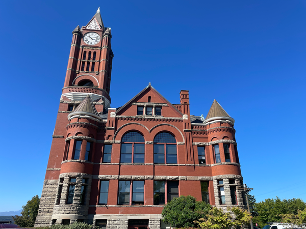 Jefferson County Courthouse. A large red brick and stone building with two towers and a clock tower up over the left side. 