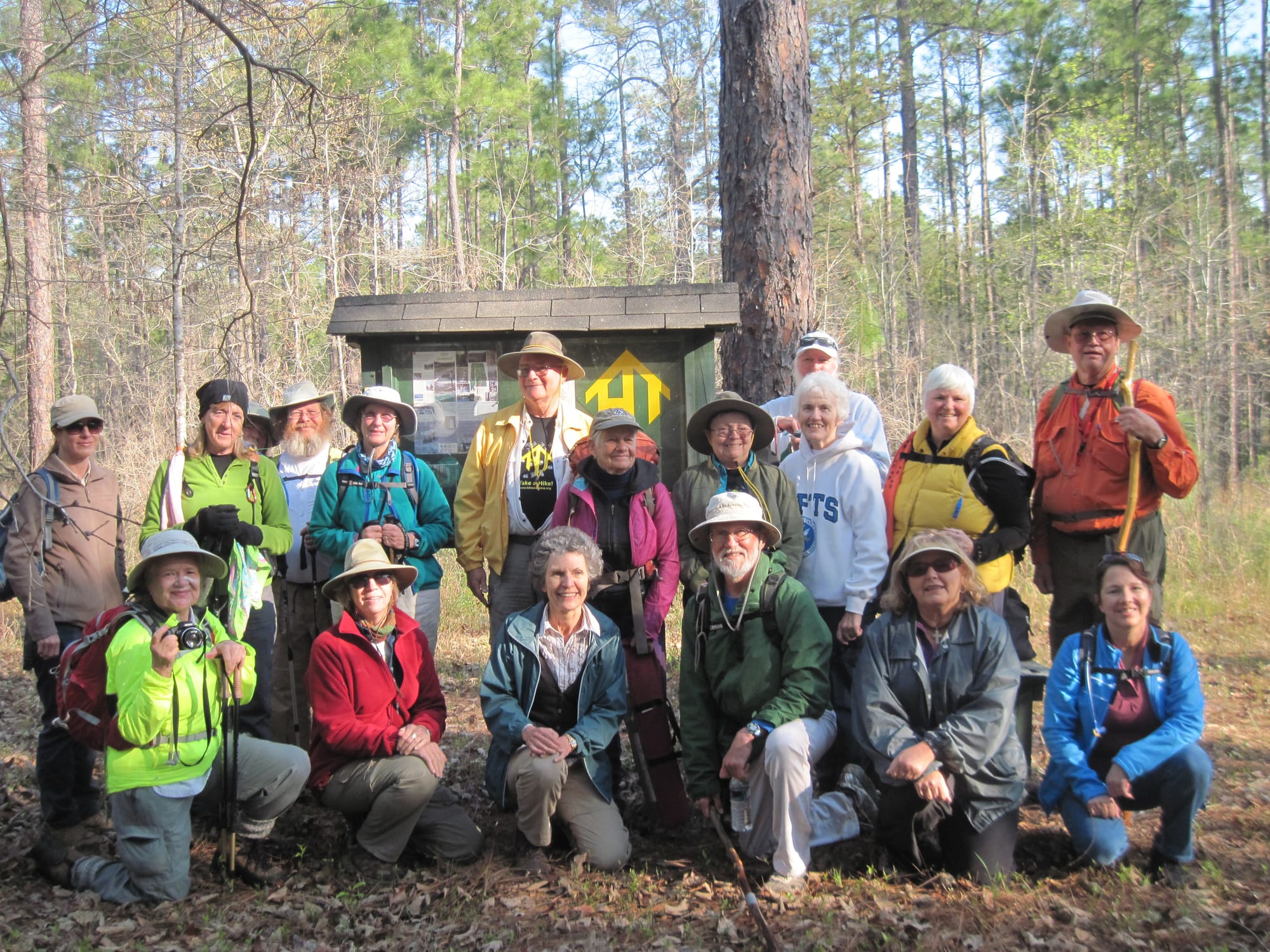 Group photo of hikers in rain gear in front of a kiosk