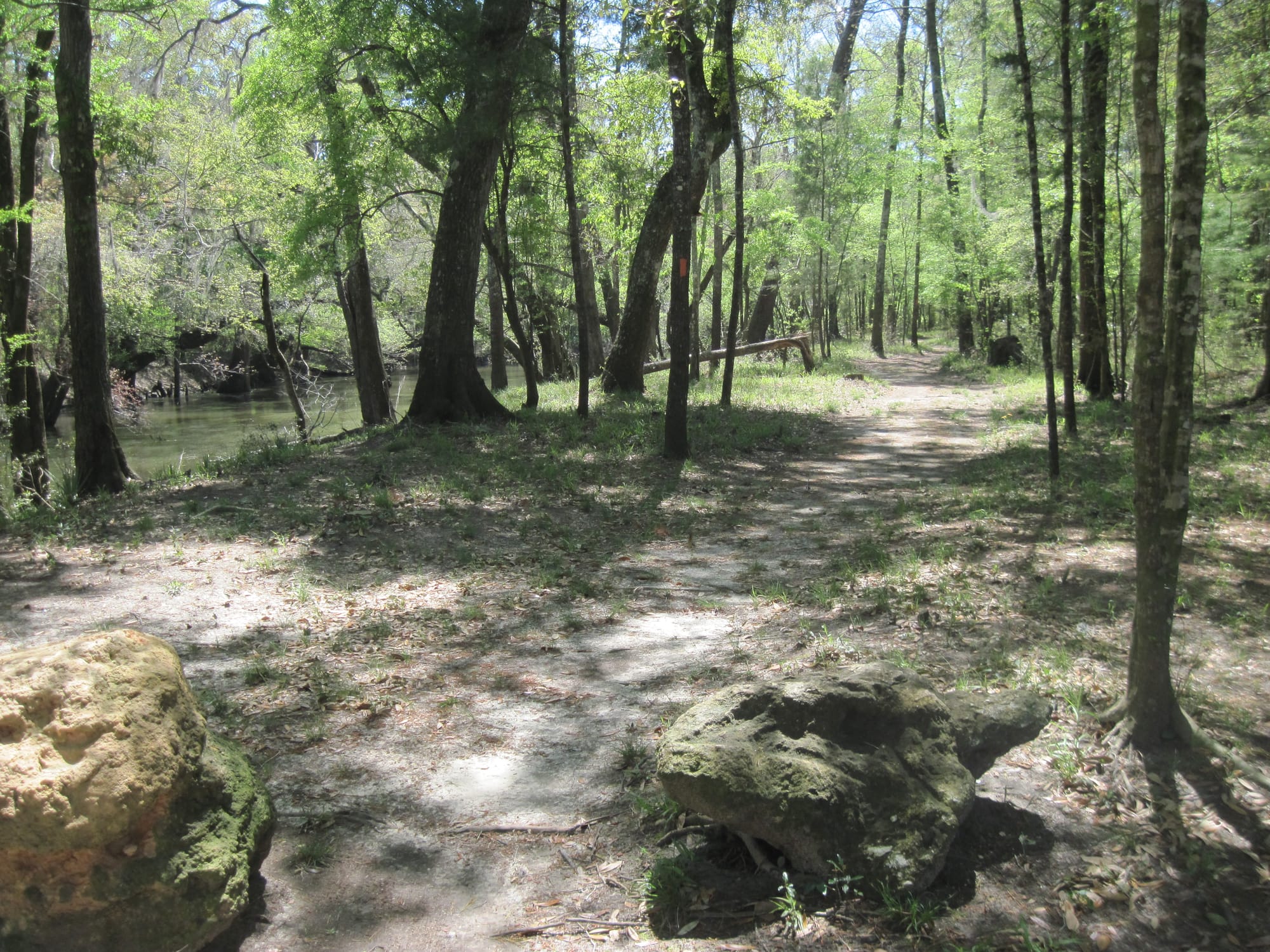 Footpath beyond large stones along a river