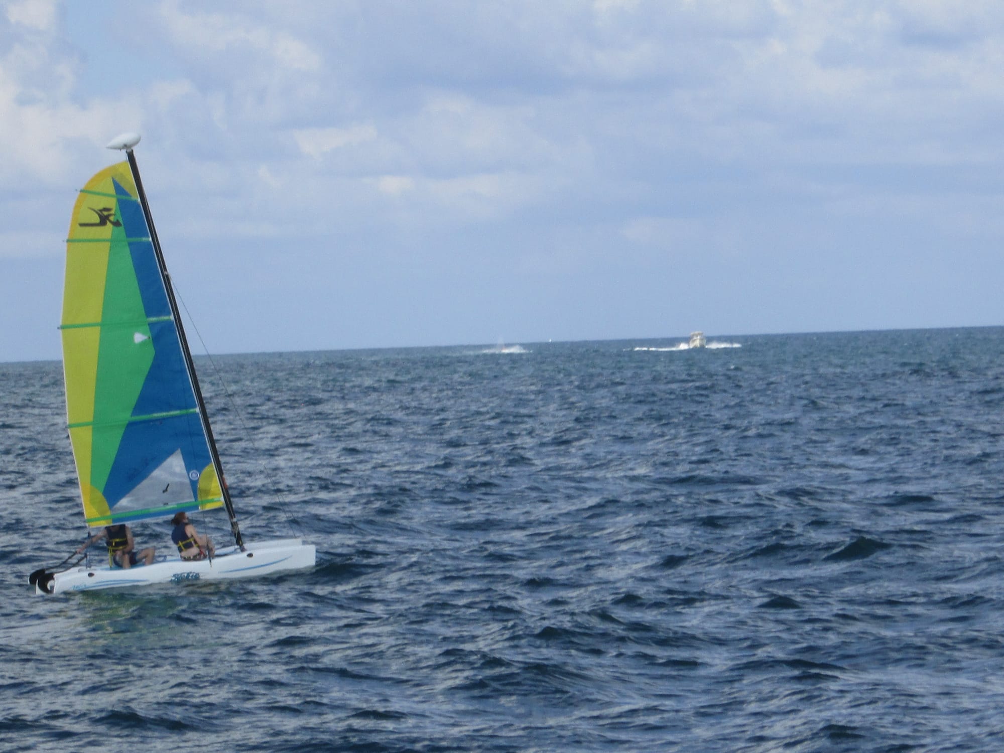 Brightly colored Hobie Cat with two aboard