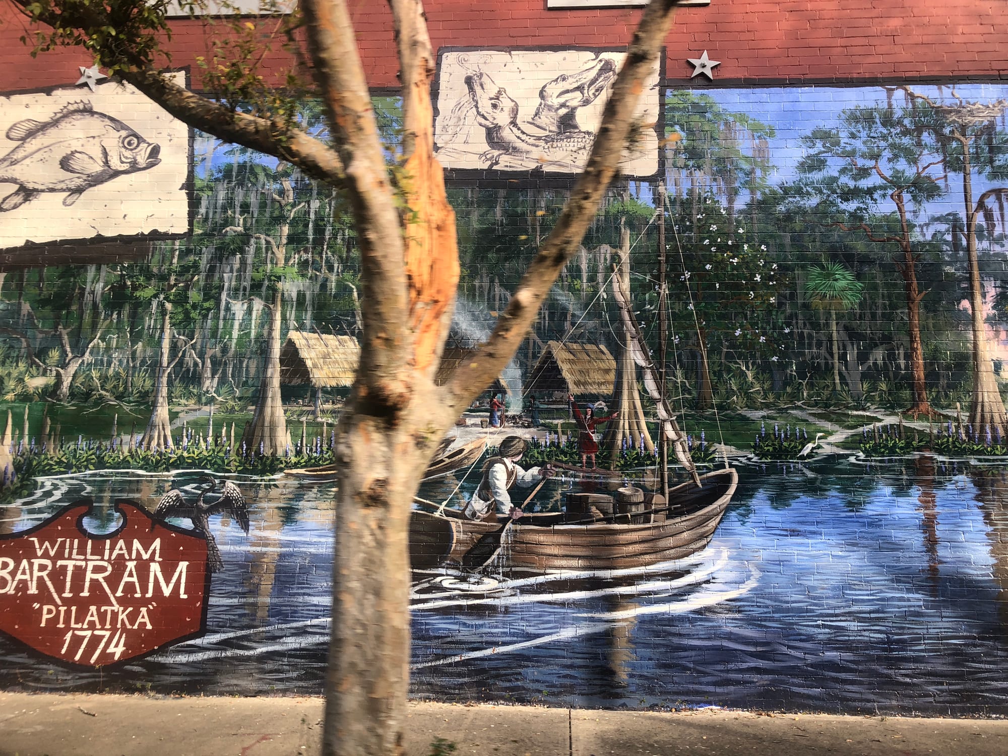 Colorful mural of sailing towards an indigenous village on a treed hillside