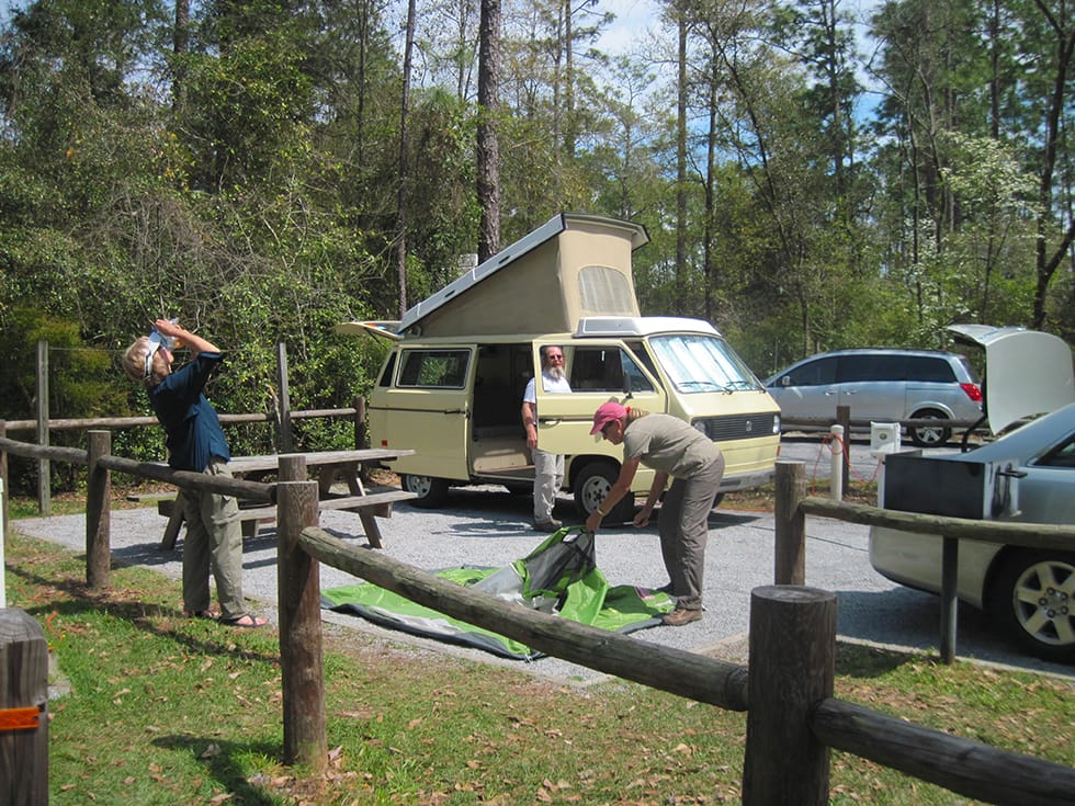 Woman pitching a tent on gravel pad