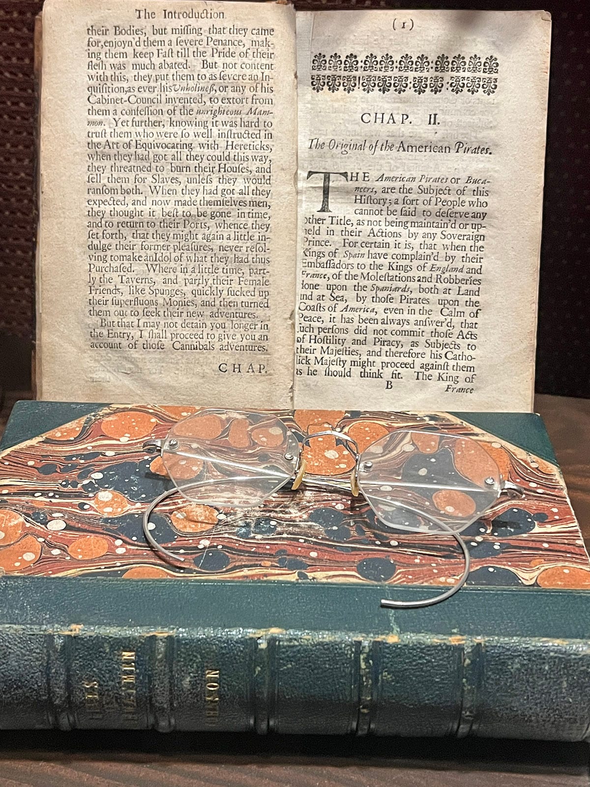 Historic manuscript on pirates in America with antique reading glasses