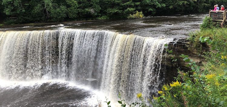 People on platform upper right looking at huge waterfall below.