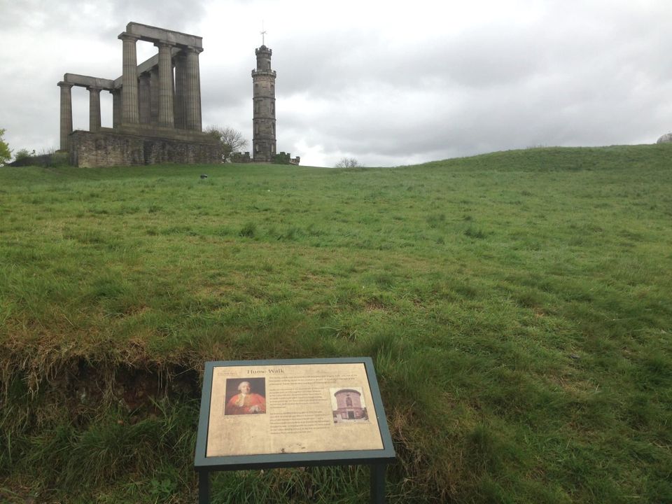 Moments on a grassy hill with interpretive sign below