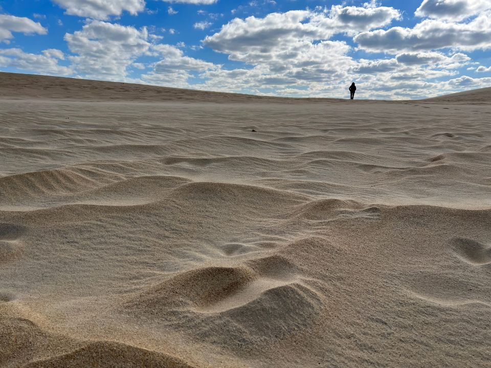 Woman's silhoutte atop a sand dune