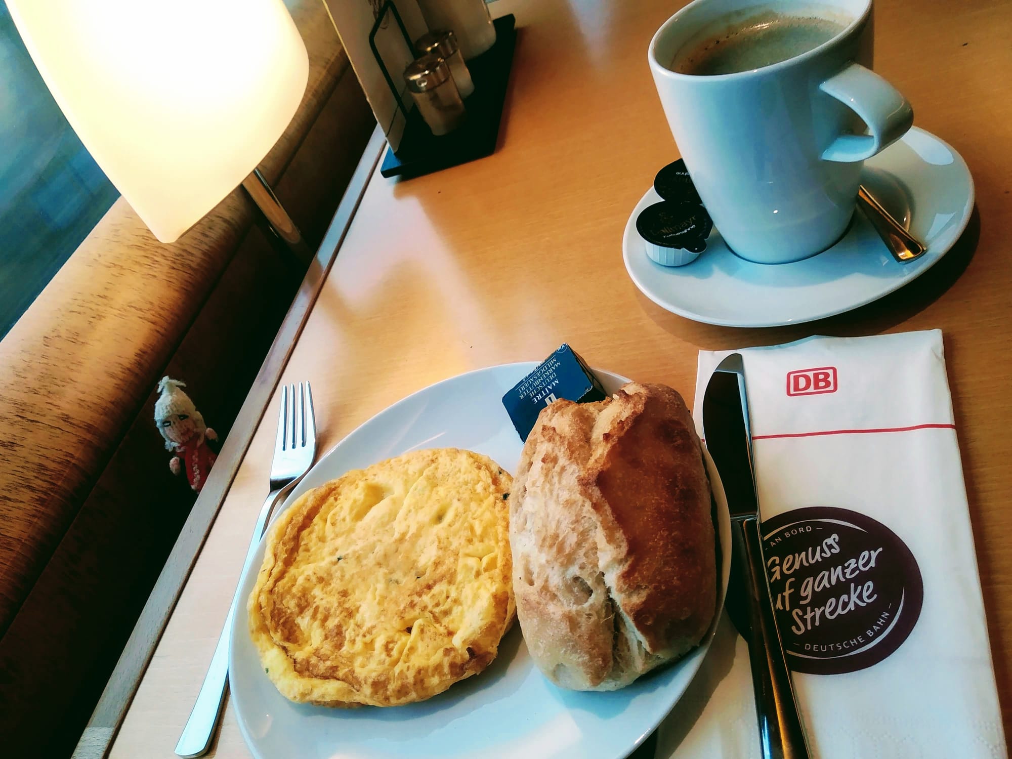A DB omelette served with a bread roll and a mug of coffee.