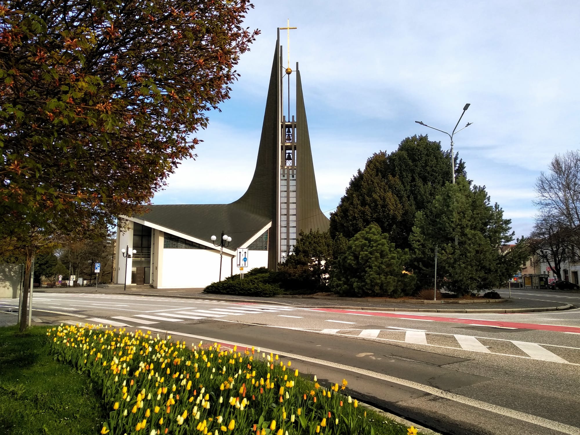 The south side of the Church of Saint Wenceslas behind trees and daffodils.