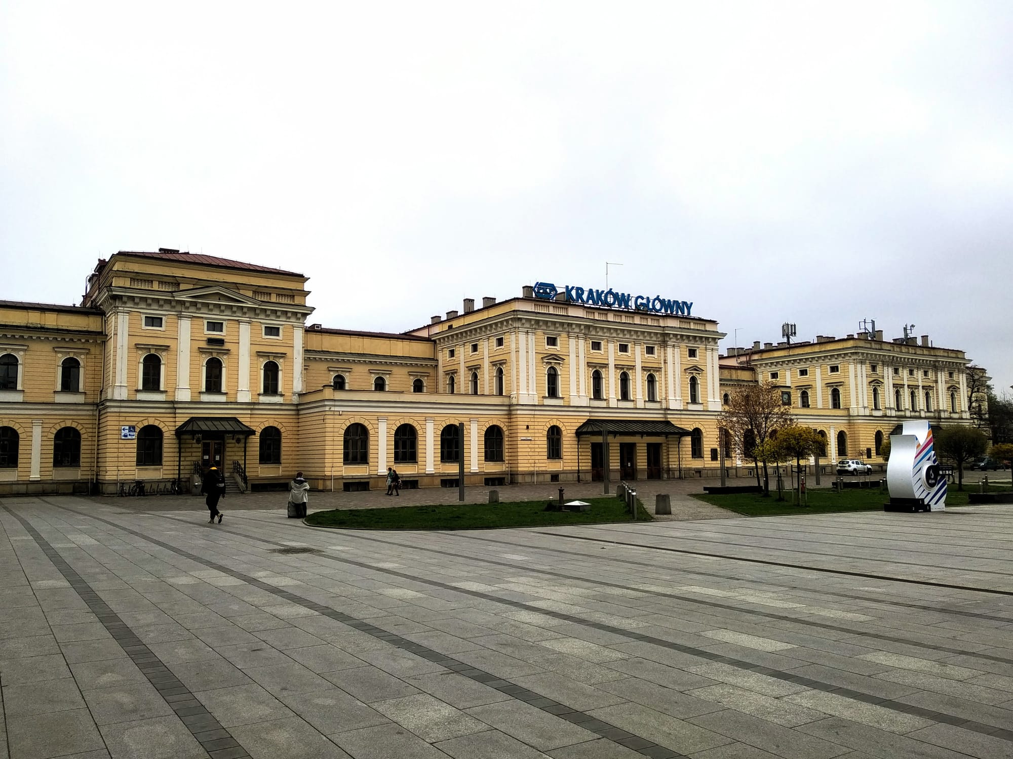 The façade of the old Kraków Glówny train station, seen across the parvis.