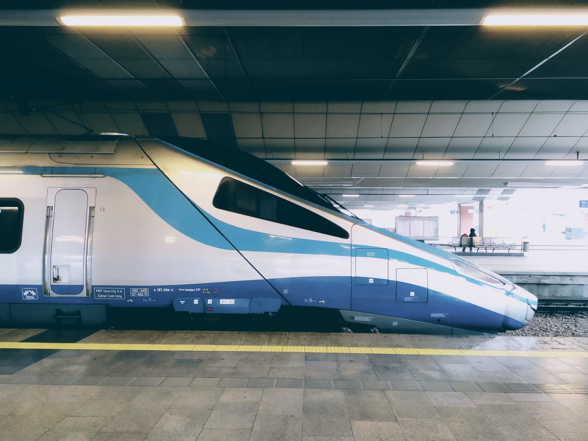 The blue and white pointy end of a Polish Pendolino train, seen from the platform.
