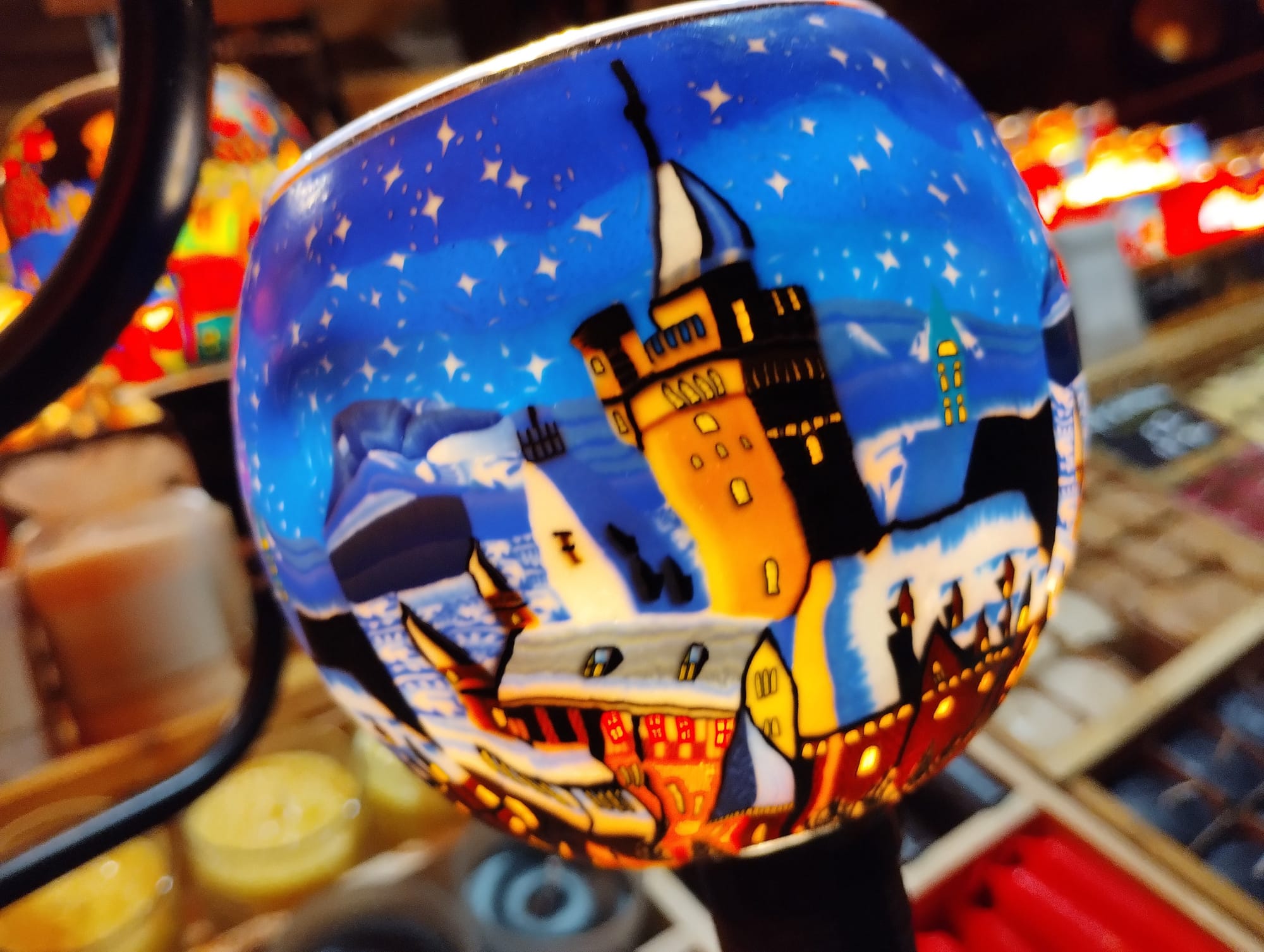 A colourful glass lamp with a painted Christmas scene.