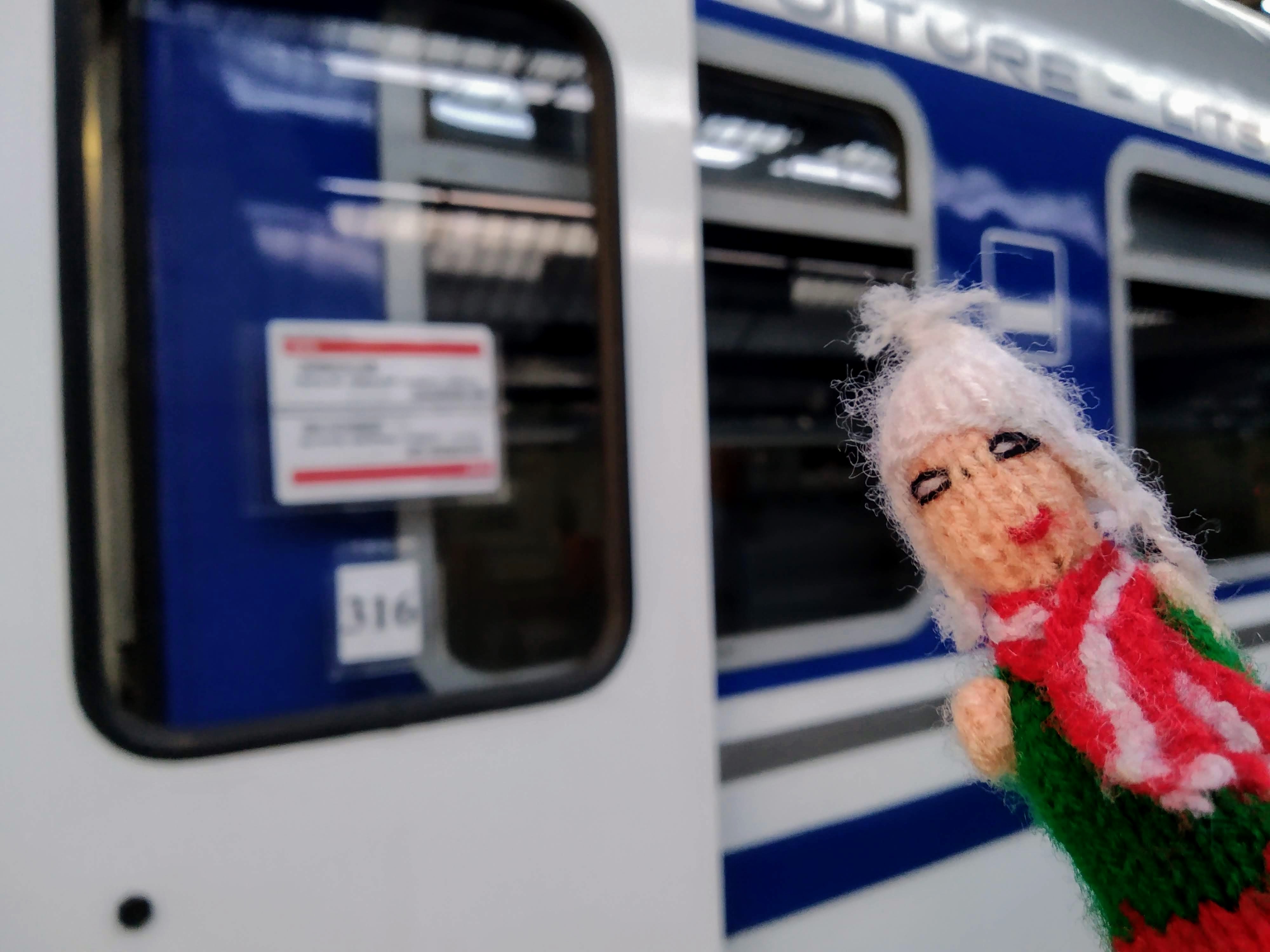 A neurotic finger puppet readies to board coach 316 of a blue and white Voiture-Lits night train.