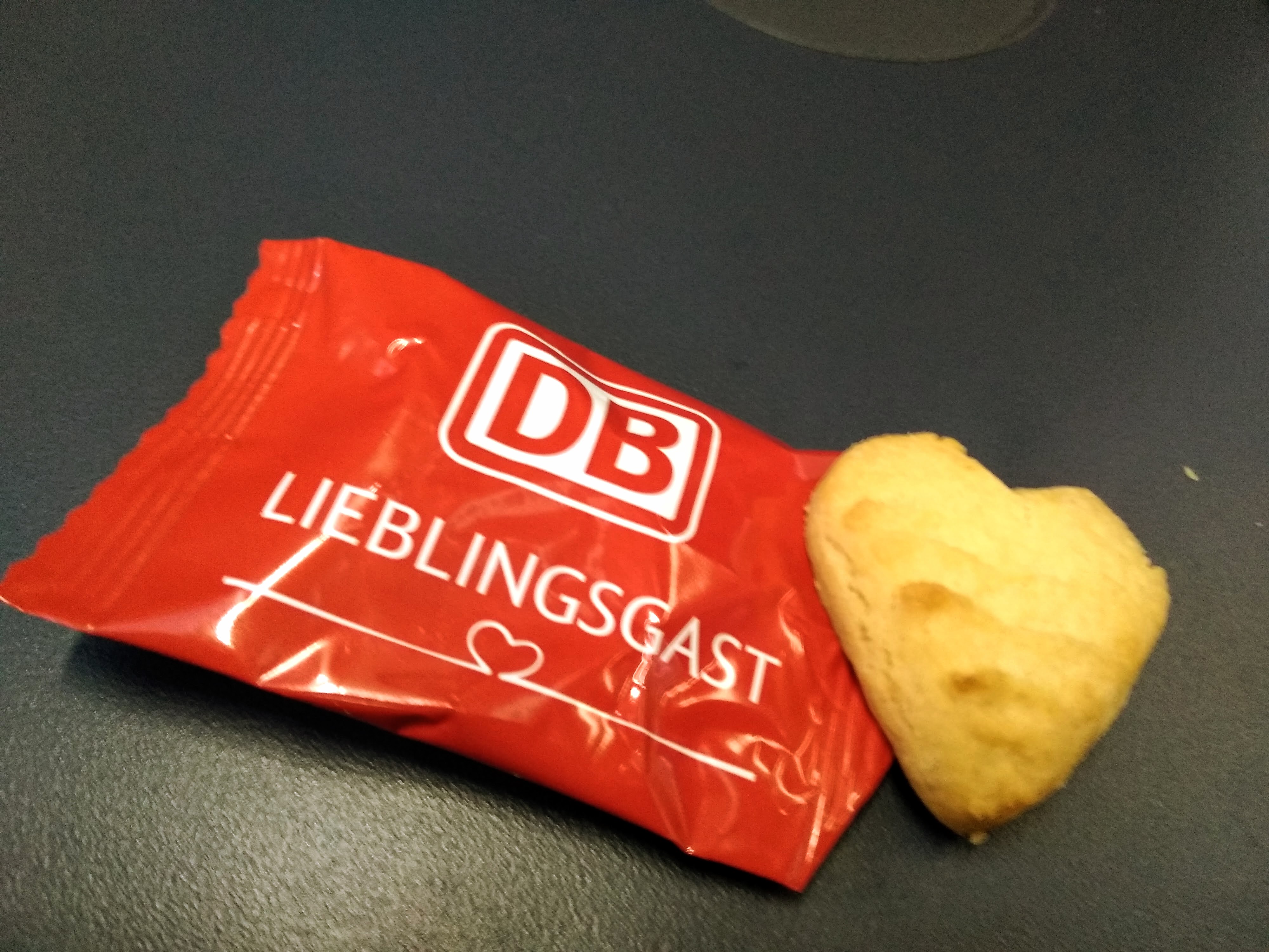 A small heart-shaped biscuit and its red sachet.