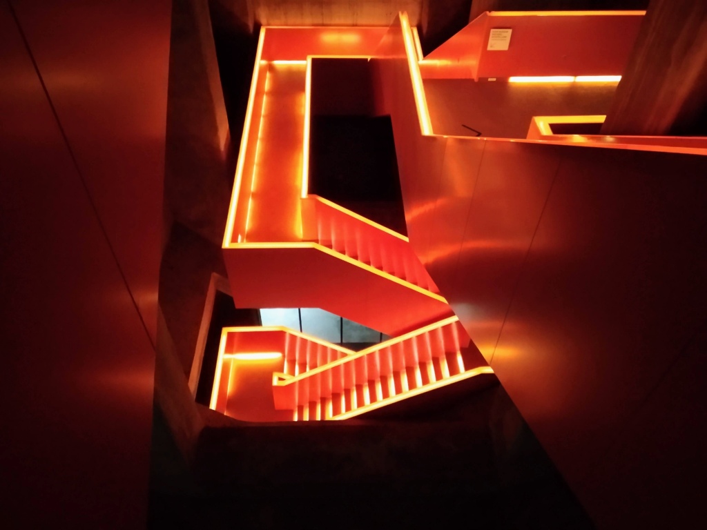 A red and orange staircase leads down to a lower level.
