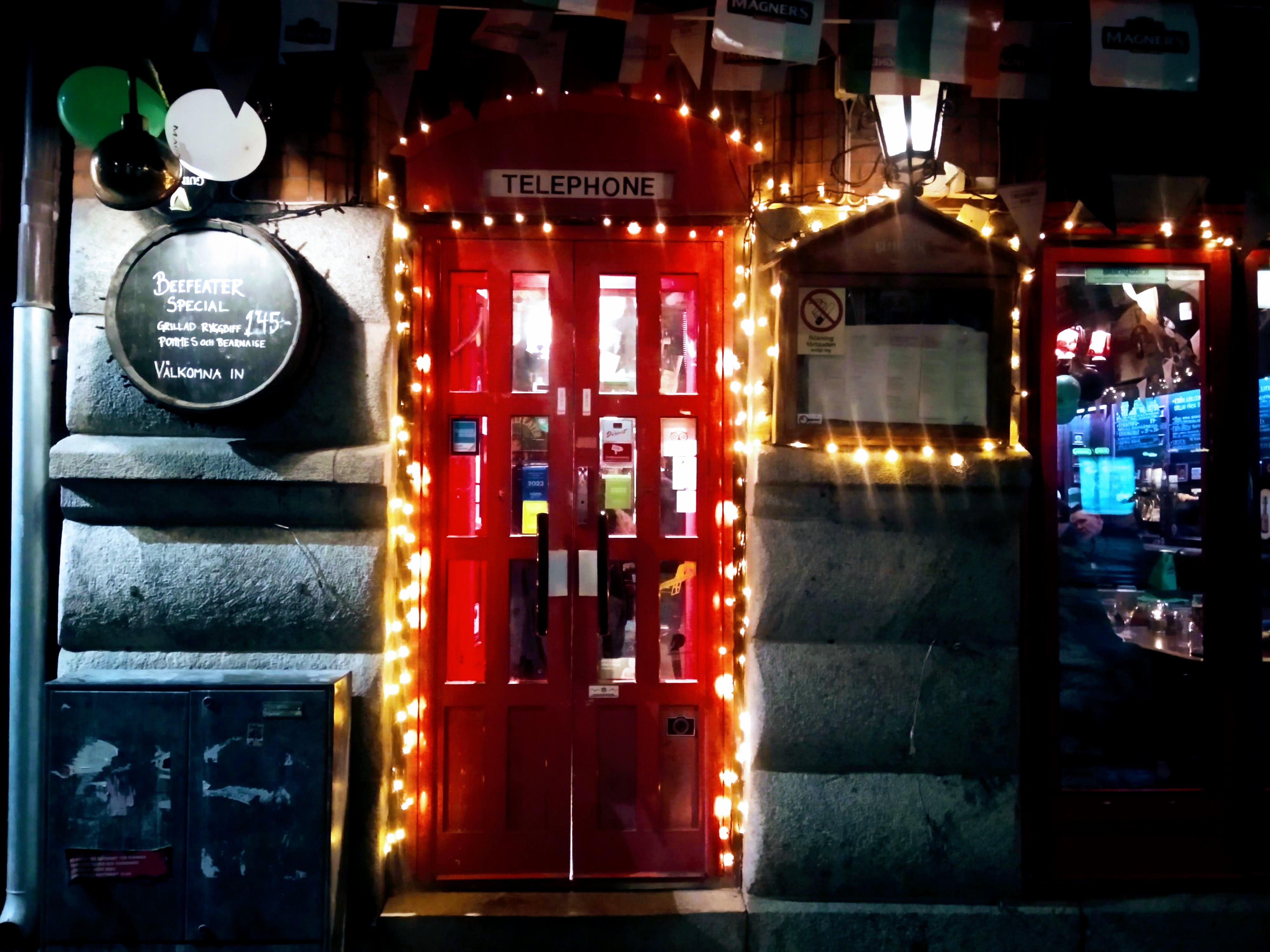 A red door in the form of a red telephone box adorned with sparkly lights.