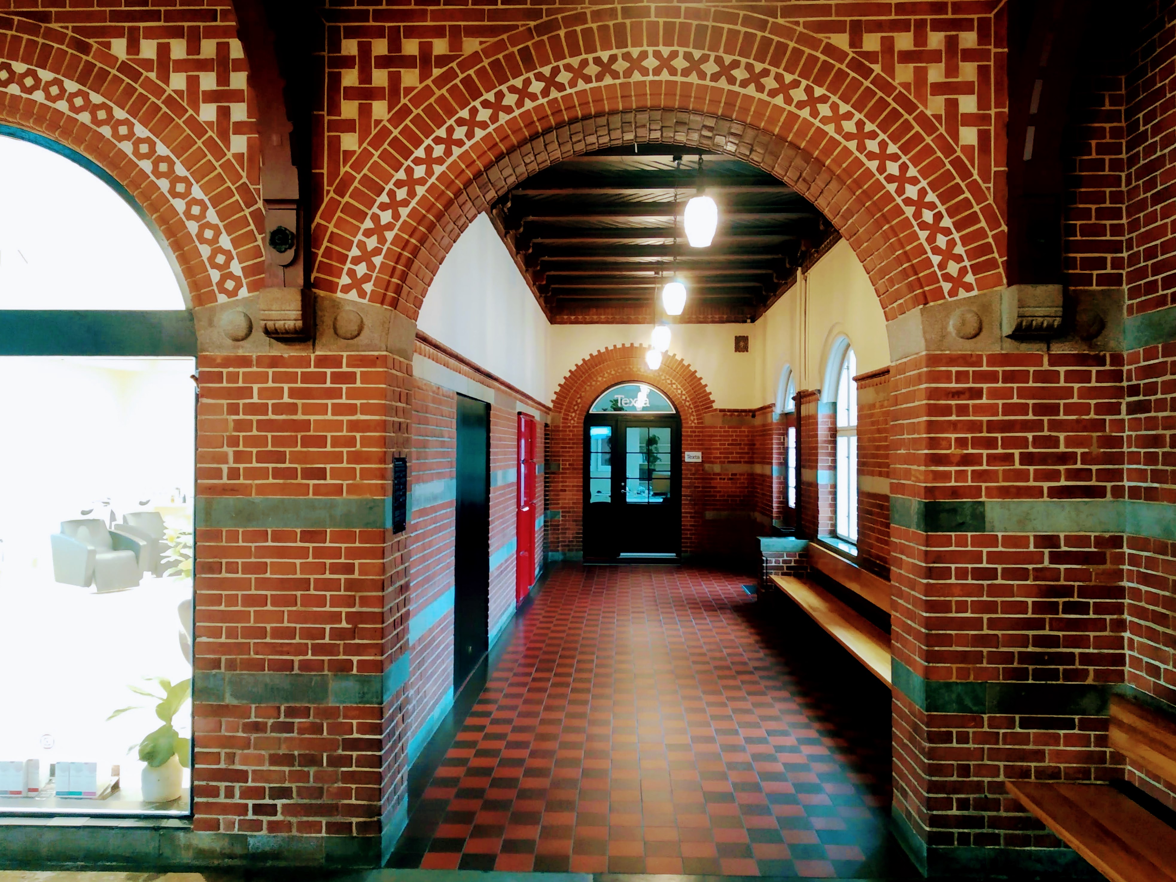 A red-brick corridor leading to a door in Holstebro station.