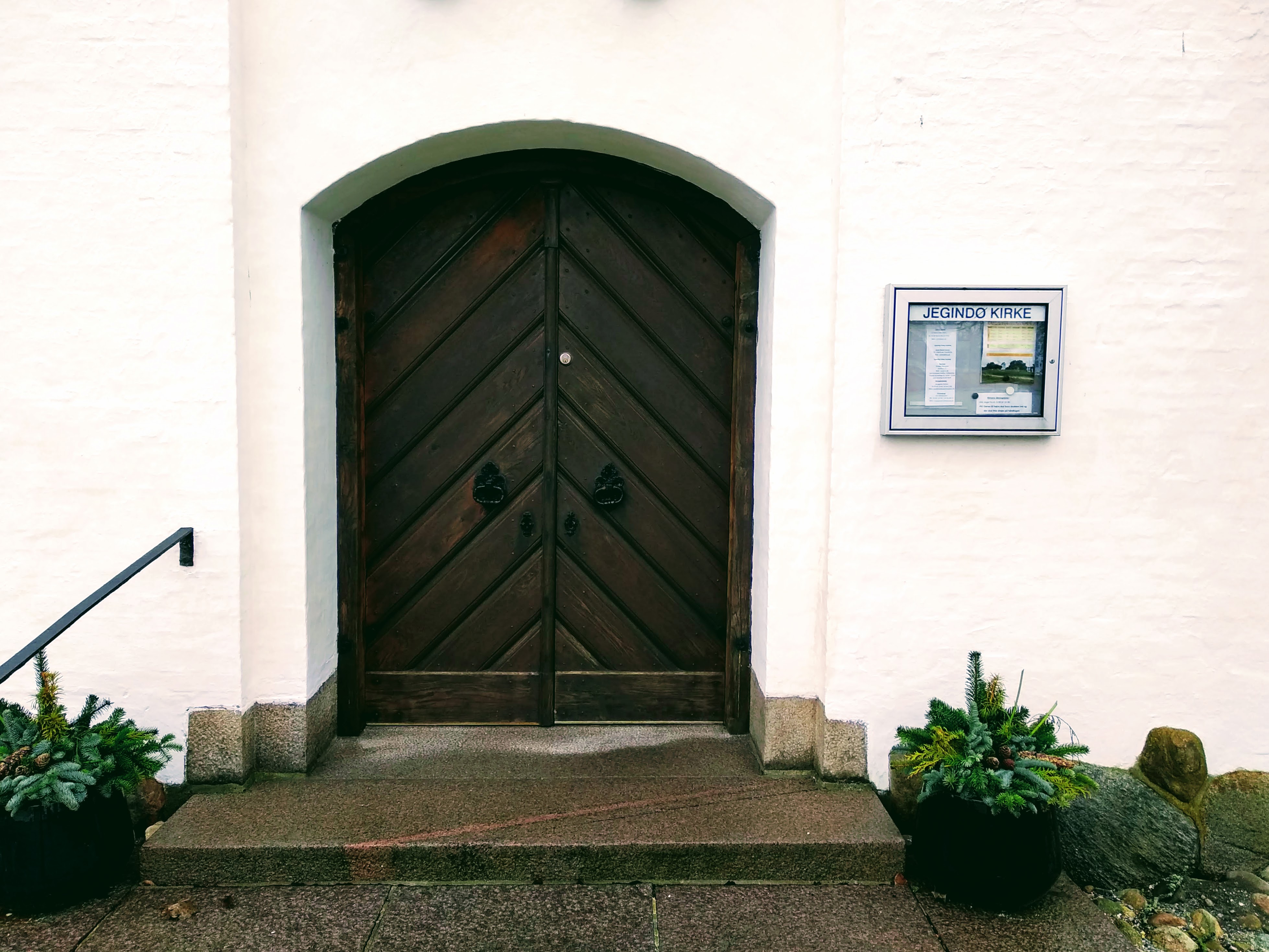 The brown wooden door to Jegindø Kirke.