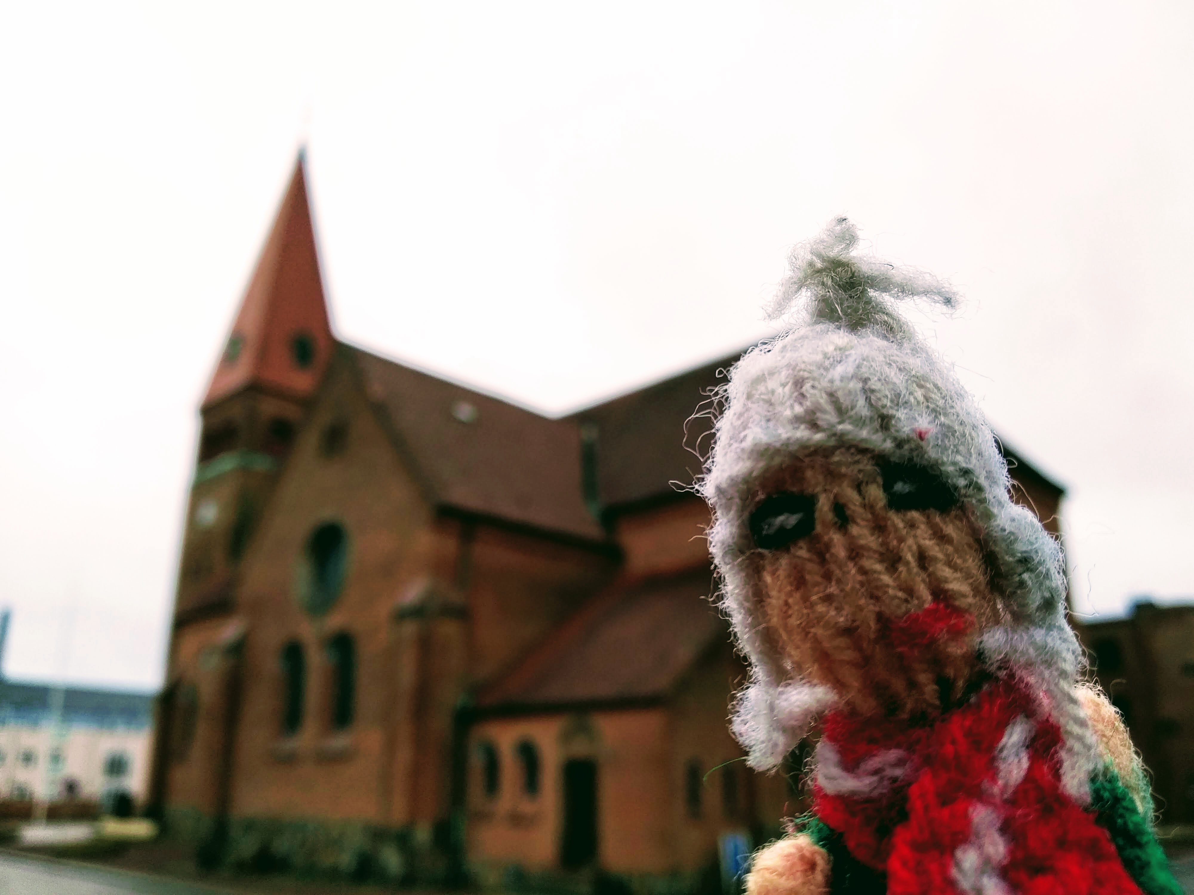 Finger puppet in front of the red brick church in Holstebro.