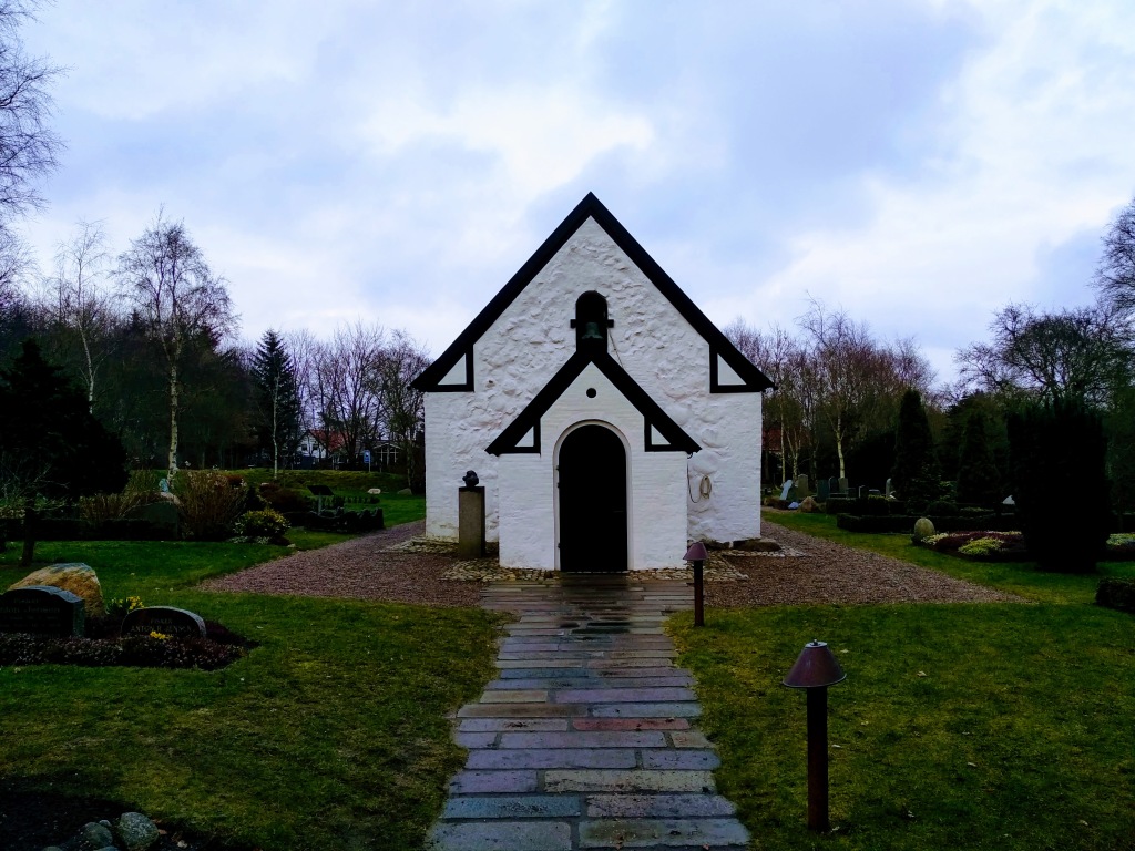 The door to Venø church at the end of a paved path.