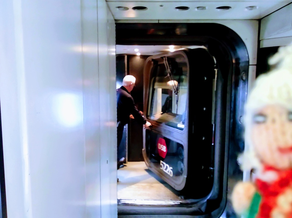 A train manager moves the driver's cab of a DSB train to form a passage between carriages.