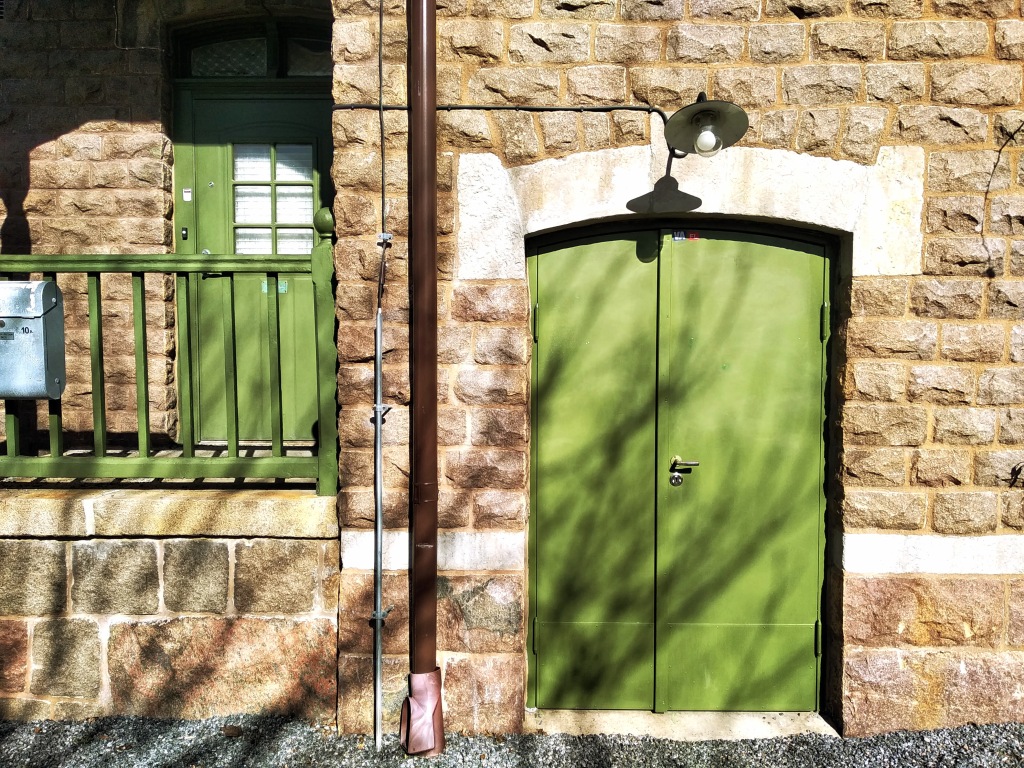 A green door in a stone wall.